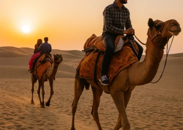 “People riding camels in the desert during sunset in Jaisalmer Rajasthan”